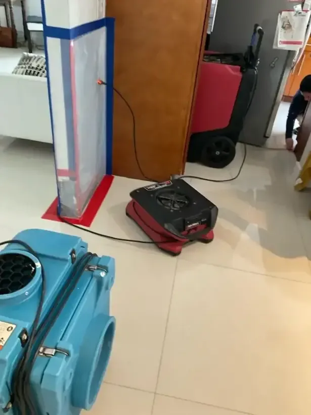 Containment doorway beside an air scrubber and dehumidifier