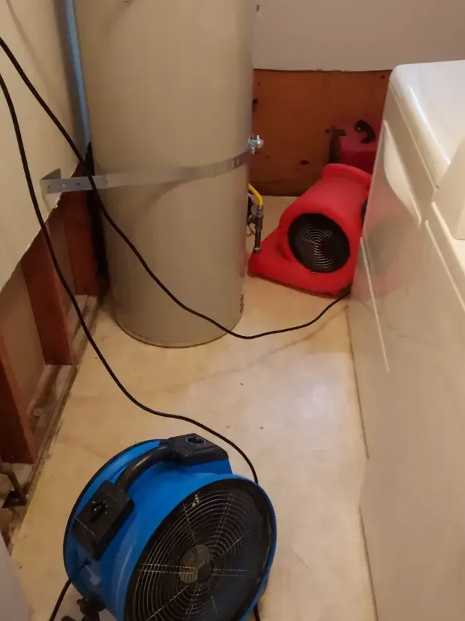 Air movers drying a laundry recess with the wall opened